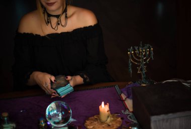  Tarot kartlarındaki kadın falcı, kehanet kavramı, sihirli ritüeller ve masanın üzerindeki cadı unsurları.