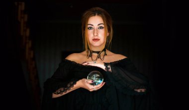 Kristal kürenin üstündeki kadın falcı, kehanetler, sihirli ritüeller ve cadılık kavramı.