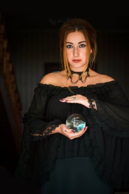 Kristal kürenin üstündeki kadın falcı, kehanetler, sihirli ritüeller ve cadılık kavramı.