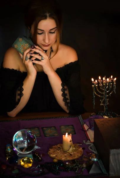  Tarot kartlarındaki kadın falcı, kehanet kavramı, sihirli ritüeller ve masanın üzerindeki cadı unsurları.