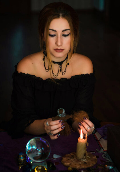 Woman make a rituals with a hair and voodoo doll , Concept of magic rituals and wicca