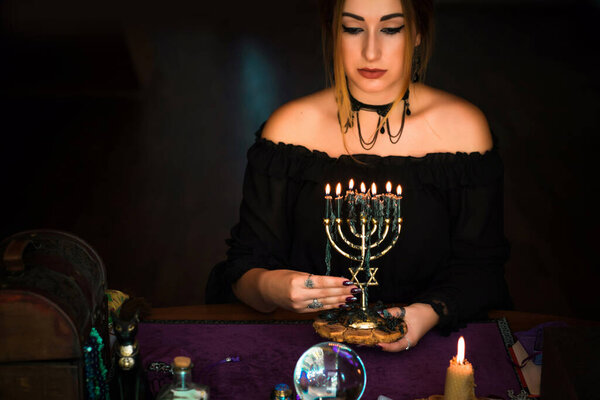 Woman holding candles, mystical scene , Concept of magic rituals and wicca