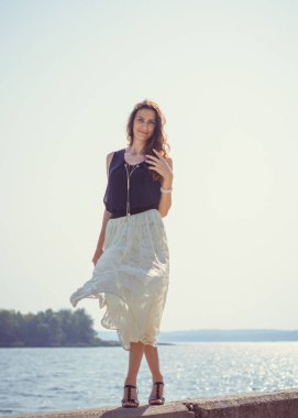 Tatilde olgun bir kadın, doğada dinleniyor, yaşam tarzı, orta yaşlı şık bir kadın güneşli bir günde doğa parkında yürüyor. 