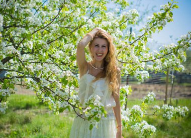 Şık, uzun, dantelli beyaz elbise giyen romantik bir kadının portresi.