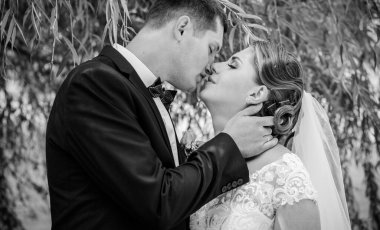 Keyifli öpücüklere sahip güzel bir düğün çifti. İhtiyacın olan tek şey aşk. Artı boyut hassasiyeti gelin ve genç damat.