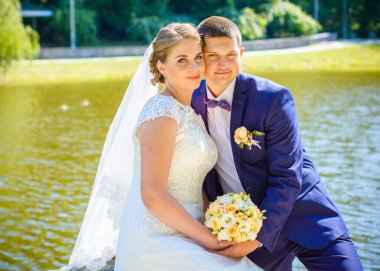 Keyifli öpücüklere sahip güzel bir düğün çifti. İhtiyacın olan tek şey aşk. Artı boyut hassasiyeti gelin ve genç damat.