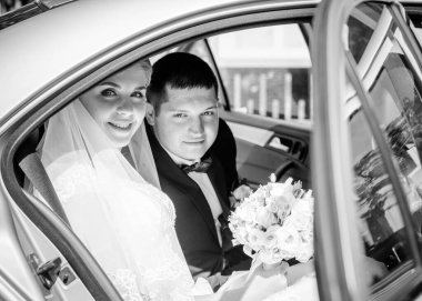 Düğün sonrası mutlu gelin ve damat. Damat gelinden daha genç. Düğün çifti, parkta yeni evliler öpüşüyor.