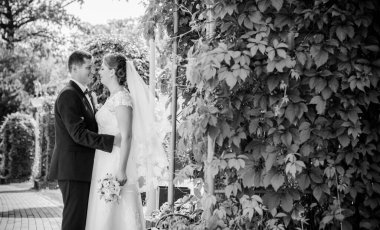 Düğün sonrası mutlu gelin ve damat. Damat gelinden daha genç. Düğün çifti, parkta yeni evliler öpüşüyor.