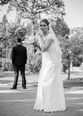 Düğün sonrası mutlu gelin ve damat. Damat gelinden daha genç. Düğün çifti, parkta yeni evliler öpüşüyor.