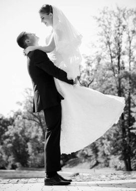 Düğün sonrası mutlu gelin ve damat. Damat gelinden daha genç. Düğün çifti, parkta yeni evliler öpüşüyor.