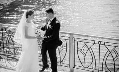 Düğün sonrası mutlu gelin ve damat. Damat gelinden daha genç. Düğün çifti, parkta yeni evliler öpüşüyor.