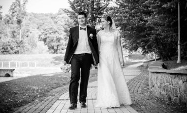 Düğün sonrası mutlu gelin ve damat. Damat gelinden daha genç. Düğün çifti, parkta yeni evliler öpüşüyor.