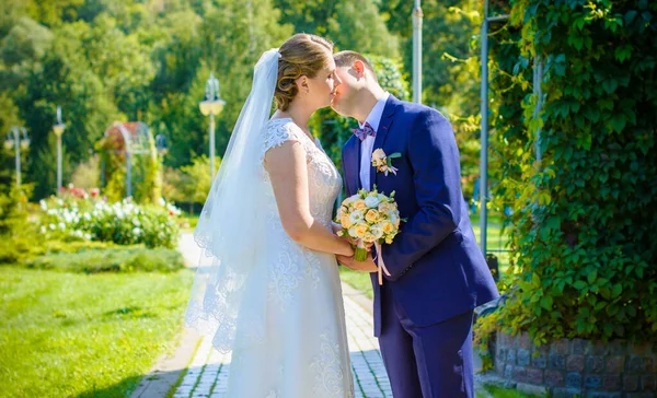 Wedding beautiful couple with good mood kisses on a nature. Love is all you need. Plus size tenderness bride and younger groom