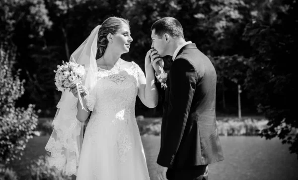 Wedding beautiful couple with good mood kisses on a nature. Love is all you need. Plus size tenderness bride and younger groom