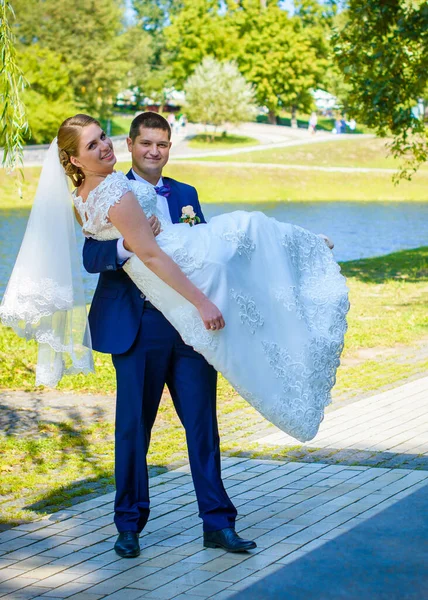 Wedding beautiful couple with good mood kisses on a nature. Love is all you need. Plus size tenderness bride and younger groom