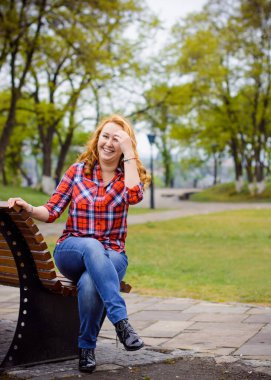 Yan komşumuz Central Park 'ta ekose gömlekli basit bir Amerikalı kız. Gülümseyerek ve gülerek eğlen.