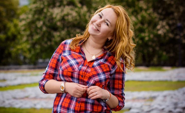 Simple american girl from next door in a plaid shirt walk in central park. Smiling and laughing have fun time