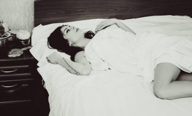 Beyaz rüyalar. Evdeyken yatakta genç ve güzel bir kadının portresi. Beyaz bir odada çıplak bir kadın.