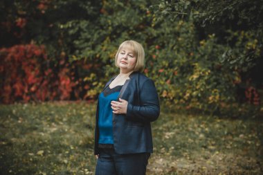 Şehirde yürüyüş yapan güzel, olgun, modaya uygun bir kadın. Sezon zamanı. Orta yaşlı, güzel bir kadın sokakta dikiliyor. Tombul kadın yaşam tarzı