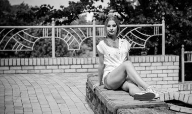 Genç sarışın kadın, öğrenci şehir parkında eğleniyor ve özgürlüğü hissediyor. Güzel Avrupalı genç bir kadın doğada dinleniyor..