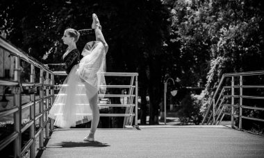 Yeşil manzarada dans eden beyaz etekli genç bir kadın. Güzel balerin klasik bale pozları veriyor. Kadın şefkati ve uyum içinde yaşam kavramı. Balerin Projesi