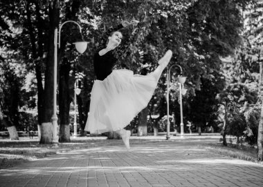 Yeşil manzarada dans eden beyaz etekli genç bir kadın. Güzel balerin klasik bale pozları veriyor. Kadın şefkati ve uyum içinde yaşam kavramı. Balerin Projesi