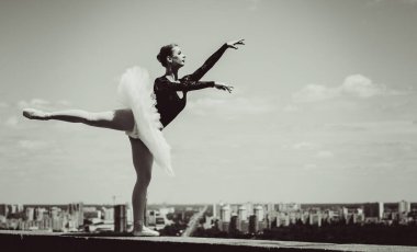 Yeşil manzarada dans eden beyaz etekli genç bir kadın. Güzel balerin klasik bale pozları veriyor. Kadın şefkati ve uyum içinde yaşam kavramı. Balerin Projesi