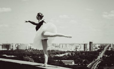 Yeşil manzarada dans eden beyaz etekli genç bir kadın. Güzel balerin klasik bale pozları veriyor. Kadın şefkati ve uyum içinde yaşam kavramı. Balerin Projesi