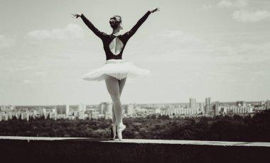 Yeşil manzarada dans eden beyaz etekli genç bir kadın. Güzel balerin klasik bale pozları veriyor. Kadın şefkati ve uyum içinde yaşam kavramı. Balerin Projesi