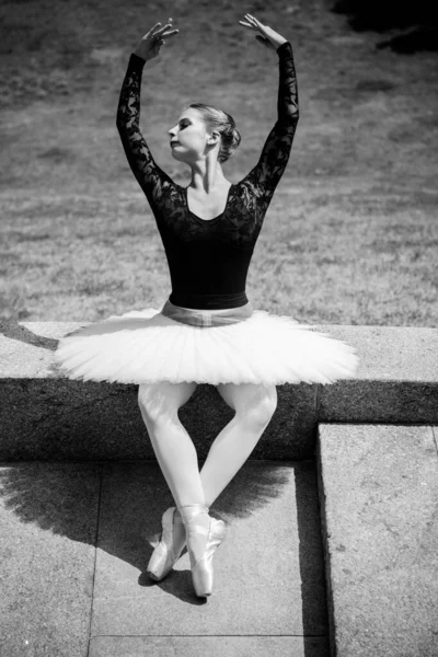 緑の風景の中で白のチュチュダンスの若い女性 空気中に古典的なバレエのポーズを示す美しいバレリーナ 女性の優しさと調和の生活の概念 バレリーナ計画 — ストック写真