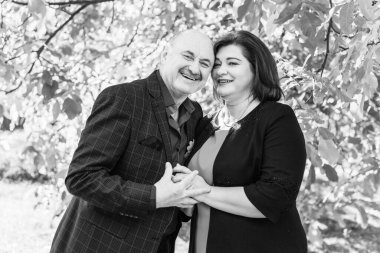 Sonbahar parkında olgun bir çift. Yaşlılarla ilişki kavramı.