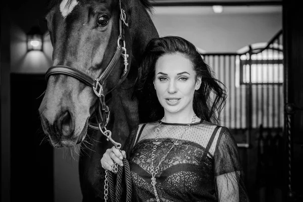 乗馬のエレガントな女性は彼女の馬に話している 帽子の女性と乗馬の肖像画 背景にライダーと古い安定した馬 — ストック写真