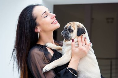 Evde sevimli köpekli hoş bir kadın var. Evcil hayvan evlat edinme, evcil hayvan hayatı. Pug taşıyan dişi, hayvanlar sağlıklı mutlu köpek yavrusu
