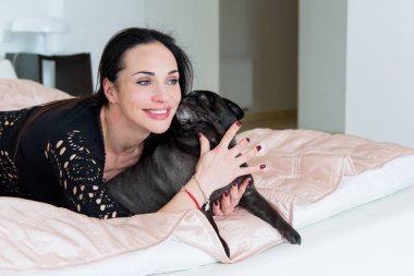 Evde sevimli köpekli hoş bir kadın var. Evcil hayvan evlat edinme, evcil hayvan hayatı. Pug taşıyan dişi, hayvanlar sağlıklı mutlu köpek yavrusu