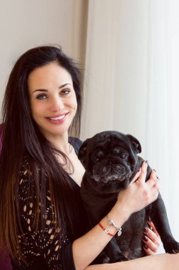 Evde sevimli köpekli hoş bir kadın var. Evcil hayvan evlat edinme, evcil hayvan hayatı. Pug taşıyan dişi, hayvanlar sağlıklı mutlu köpek yavrusu