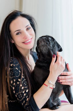 Evde sevimli köpekli hoş bir kadın var. Evcil hayvan evlat edinme, evcil hayvan hayatı. Pug taşıyan dişi, hayvanlar sağlıklı mutlu köpek yavrusu