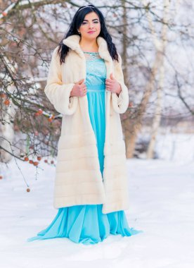 Moda konsepti. Tatillerde güzel bir Arap kadın, modern bir kadın kürk giyiyor. Havalı bayan açık hava portresi.