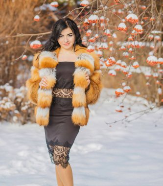 Moda konsepti. Tatillerde güzel bir Arap kadın, modern bir kadın kürk giyiyor. Havalı bayan açık hava portresi.