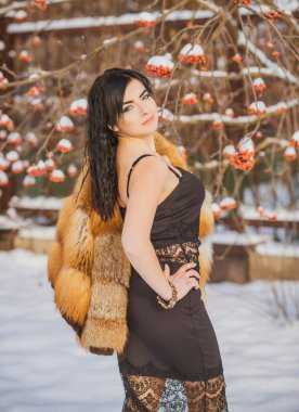 Moda konsepti. Tatillerde güzel bir Arap kadın, modern bir kadın kürk giyiyor. Havalı bayan açık hava portresi.