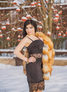 Moda konsepti. Tatillerde güzel bir Arap kadın, modern bir kadın kürk giyiyor. Havalı bayan açık hava portresi.