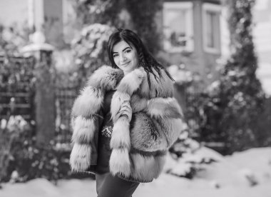 Moda konsepti. Tatillerde güzel bir Arap kadın, modern bir kadın kürk giyiyor. Havalı bayan açık hava portresi.