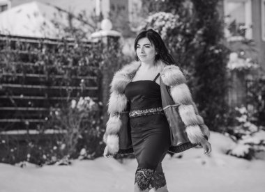 Moda konsepti. Tatillerde güzel bir Arap kadın, modern bir kadın kürk giyiyor. Havalı bayan açık hava portresi.