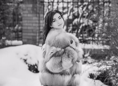 Moda konsepti. Tatillerde güzel bir Arap kadın, modern bir kadın kürk giyiyor. Havalı bayan açık hava portresi.