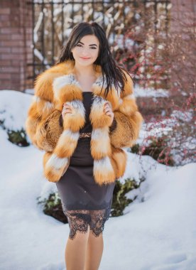 Moda konsepti. Tatillerde güzel bir Arap kadın, modern bir kadın kürk giyiyor. Havalı bayan açık hava portresi.