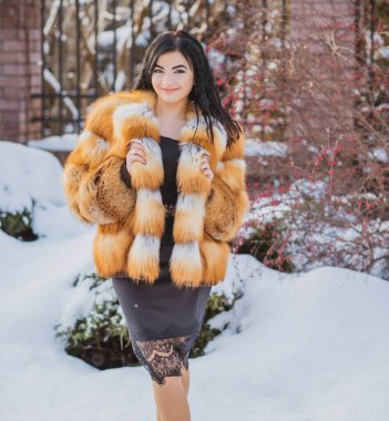 Moda konsepti. Tatillerde güzel bir Arap kadın, modern bir kadın kürk giyiyor. Havalı bayan açık hava portresi.