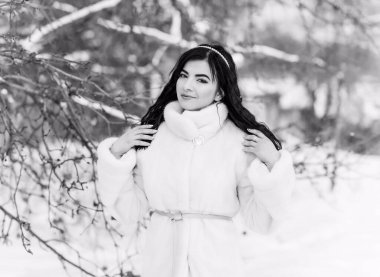 Moda konsepti. Tatillerde güzel bir Arap kadın, modern bir kadın kürk giyiyor. Havalı bayan açık hava portresi.