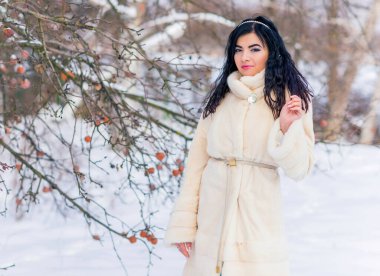 Moda konsepti. Tatillerde güzel bir Arap kadın, modern bir kadın kürk giyiyor. Havalı bayan açık hava portresi.