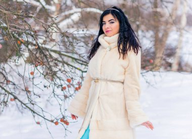 Moda konsepti. Tatillerde güzel bir Arap kadın, modern bir kadın kürk giyiyor. Havalı bayan açık hava portresi.
