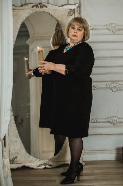 Mistik ortamda olgun bir kadın, masadaki tarot kartı manzarası, esrarengiz kavram, falcılık ve tahminler.