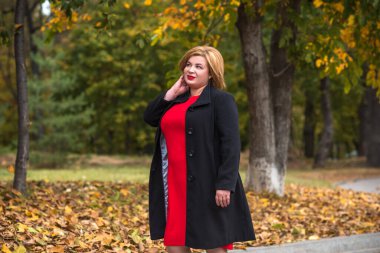 Klasik görünümlü orta yaşlı kadın parka bakıyor, tombul bayanlar için şık bir tarz. Olgun moda artı boyut kadın, orta yaşlı kadın yaşam tarzı kavramı.